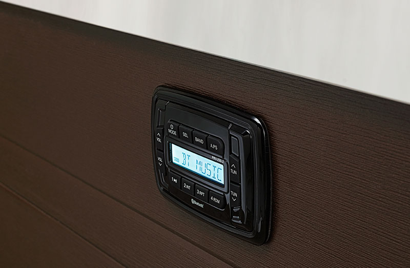 image showing the cosmic audio unit installed on a brown cabinet in a Vector21 Hot Tub