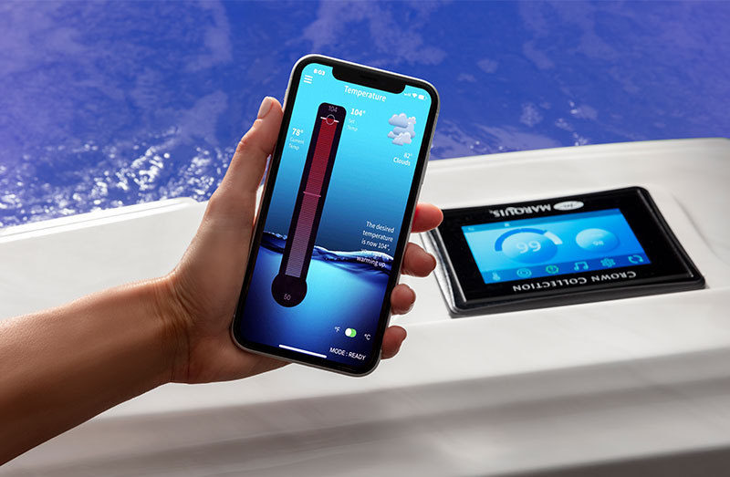 hand holding phone next to a controlmyspa screen and checking temperature of the hot tub
